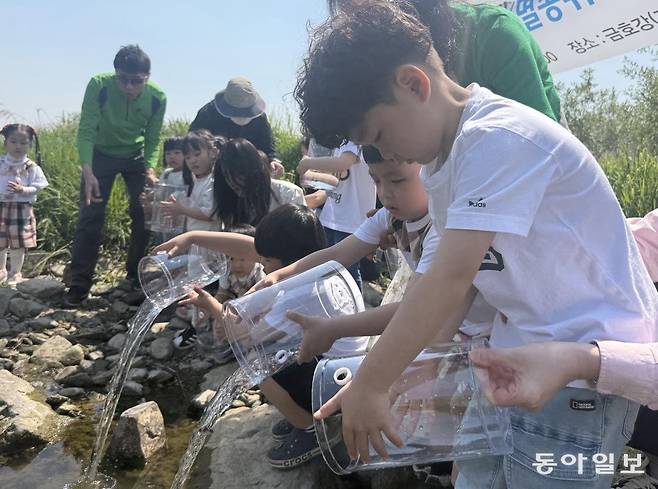 어린이들이 각자 받은 어항에서 꼬치동자개를 방류하는 모습. 경산=전채은 기자 chan2@donga.com