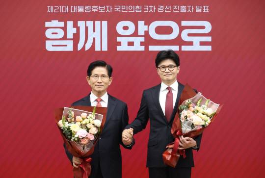 국민의힘 대선 최종 경선에 진출한 김문수(왼쪽)·한동훈 후보가 29일 중앙당사에서 2차 경선 결과 발표 후 꽃다발을 들고서 기념촬영 하고 있다. [국회사진기자단]