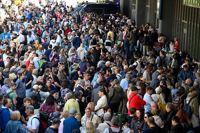 28일(현지 시각) 스페인 바르셀로나에 정전이 발생해 사람들이 기차역 밖에서 라디오 방송을 듣고 있다. 사진=AFP 연합뉴스