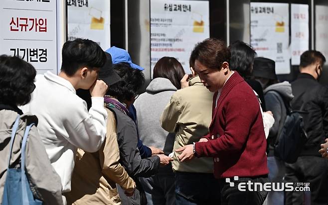 SK텔레콤 유심 해킹 사태로 인한 무상 교체 2일 차인 29일 서울 서초구의 한 SKT 직영대리점에서 관계자가 가입자들에게 번호표를 나눠주고 있다.  이동근기자 foto@etnews.com