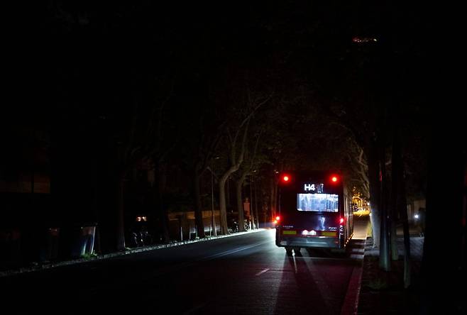 스페인이 28일(현지시간) 나라 전역의 대규모 정전으로 비상사태를 선포한 가운데 이날 칠흑 같은 어둠에 잠긴 바르셀로나 밤거리를 버스가 지나고 있다. 페드로 산체스 스페인 총리는 아직 정전 원인이 다 밝혀지지 않아 전력망 복구에 시간이 걸리고 있다고 말했다. AFP 연합