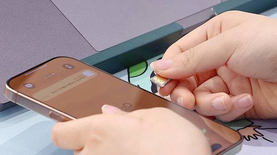 가입자 유심(USIM) 정보를 탈취당한 SK텔레콤이 유심 무료교체 서비스를 시작한 지난 28일 서울 시내 한 SKT 대리점에서 직원이 유심 교체를 하고 있다. 연합뉴스