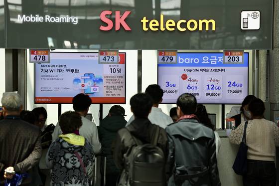 29일 오전 인천국제공항 제1여객터미널 SK텔레콤 로밍센터에서 출국자들이 유심 교체을 위해 대기하고 있다. [뉴시스]