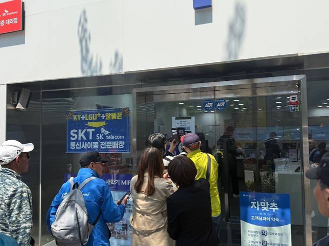 유심 해킹 사고가 발생한 SK텔레콤이 전 고객을 대상으로 유심 무상 교체를 실시한 지난 28일 서울의 한 SK텔레콤 대리점을 찾은 고객들이 유심칩을 교체하기 위해 대기하고 있다. /김유진기자