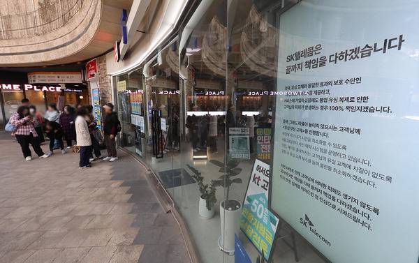 가입자 유심(USIM) 정보를 탈취당한 SK텔레콤이 유심 무료교체 서비스를 시작한 지 이틀째인 29일 서울 시내 한 SKT 대리점에 'SK텔레콤은 끝까지 책임을 다하겠습니다'라는 문구가 쓰여져 있다. 연합뉴스