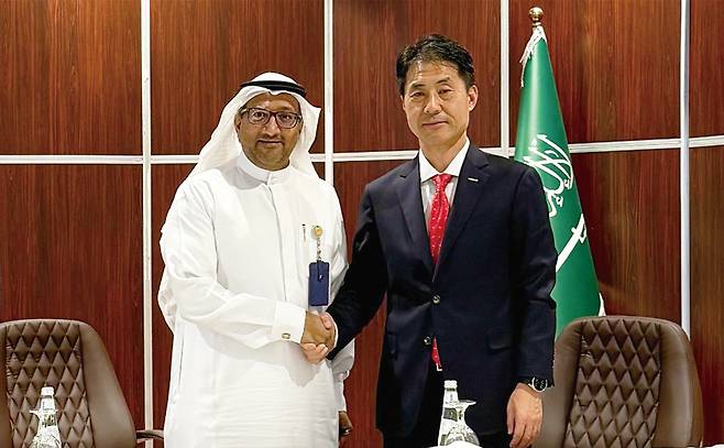 Jamal Abdulrahman Omar (left), vice president of operations and maintenance at Marafiq, and Sohn Seung-woo, CEO of Doosan Enerbility’s power service business group, shake hands during the signing ceremony for the Yanbu 2 Power Plant fuel conversion project, held Sunday in Jubail, Saudi Arabia. (Doosan Enerbility)
