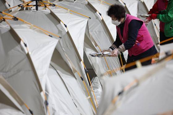 Volunteers and government officials move breakfast meals at a shelter set up at Paldal Elementary School in Daegu's Buk District on April 29, the second day of a large wildfire that broke out on Mount Hamji. [YONHAP]