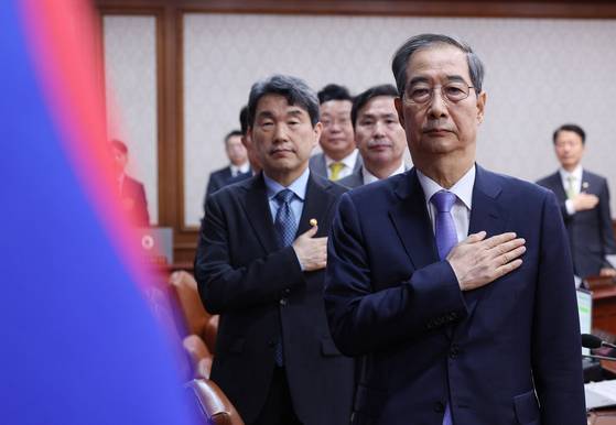 Acting President and Prime Minister Han Duck-soo pledges allegiance to the Korean flag before a Cabinet meeting held at the government complex in Jongno District, central Seoul on April 29. [JOINT PRESS CORPS]
