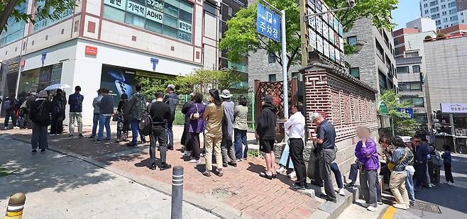SK Telecom subscribers are lined up in front of the mobile carrier’s branch in Seoul during lunchtime on April 29 to replace their SIM cards. [YONHAP]