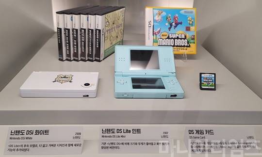 넷마블게임박물관. 닌텐도 DS의 개선 제품들인 '닌텐도 DS Lite'(2007년, 아래 중앙)과 '닌텐도 DSi'.(2009년, 아래 왼쪽), 그리고 게임 팩들. (위 왼쪽부터 '마리오카트DS', '레이튼 교수와 이상한 마을', '도와줘! 리듬 히어로', '젤다의 전설 몽환의 모래시계', '매일매일 DS 두뇌 트레이닝', '말랑말랑 두뇌교실', '뉴 슈퍼 마리오 부르스'. 닌텐도 DS의 오리지널 제품은 2004년 첫 발매 됐는데, 전세계적으로 1억 5402만 대(2016년 기준 누적 판매대수)가 팔려 닌텐도의 가장 많이 팔린 게임기로 꼽힌다. 듀얼스크린이 특징이며, 하단의 터치스크린은 감압식이다. 경쟁작은 당시 성능이 훨씬 뛰어난 소니의 '플레이스테이션포터블'(PSP)였는데, 저렴한 가격을 무기로 2배의 판매량을 기록하며 시장의 선두주자가 됐다. 와이파이를 탑재해 멀티플레이를 지원했던 것도 특징인데, 와이파이 탑재는 아이폰보다도 먼저였다. 촬영 : 이동근 기자