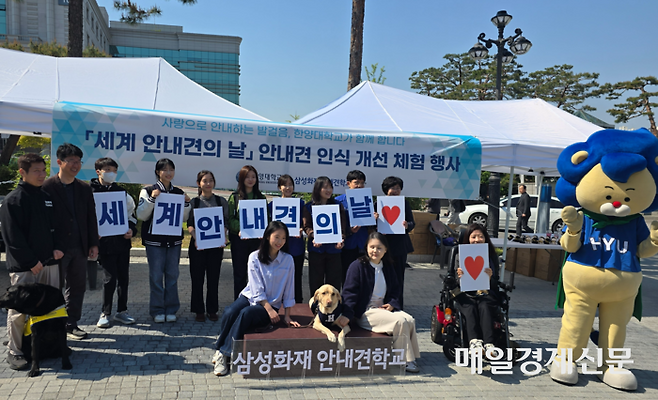 29일 서울 성동구 한양대에서 세계 안내견의 날을 맞아 열린 안내견 체험 행사에서 안내견 ‘정성’이와 장승희 씨 및 관계자들이 사진 촬영을 하고 있다. [양세호 기자]