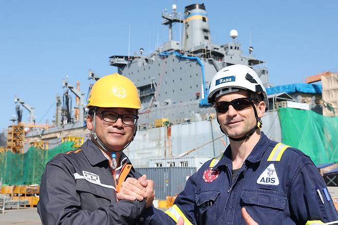 박정훈 한화오션 특수선 MRO TF팀 책임(왼쪽)과 볼로디미르 보로베츠 미국선급협회(ABS) 수석검사관이 조선소에서 손을 맞잡은 모습. 한화오션