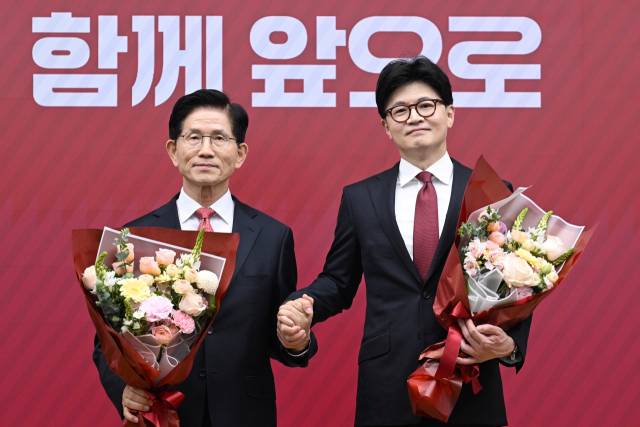 ▲국민의힘 대선 최종 경선에 진출한 김문수(왼쪽)·한동훈 후보가 29일 서울 여의도 당사에서 3차 경선 결과 발표 후 꽃다발을 들고서 기념 촬영하고 있다. ⓒ연합뉴스