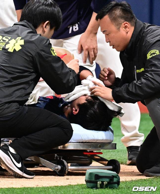롯데 전민재(가운데)가 29일 키움전 7회초 투구에 얼굴을 맞아 쓰러져 들것에 몸을 옮겨지고 있다.