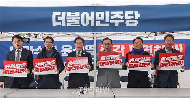 더불어민주당 박용진 전 의원, 김경수 전 경남도지사, 이재명 대표, 김부겸 전 국무총리, 이광재 전 국회사무총장, 임종석 전 청와대 비서실장(사진 왼쪽부터)이 지난달 12일 서울 종로구 경복궁 앞 민주당 천막농성장에서 열린 국난극복을 위한 시국간담회에서 피켓을 들고 구호를 외치고 있다. ⓒ데일리안 홍금표 기자