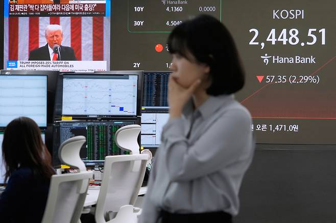 U.S. President Donald Trump is seen on a screen as a currency trader works at the foreign exchange dealing room of the Hana Bank headquarters in Seoul on April 3. [AP/YONHAP]