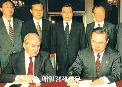 1997년 12월 당시 임창열 부총리 겸 재정경제원 장관이 정부 세종로 종합청사에서 미셸 캉드쉬 총재가 지켜보는 가운데 IMF SDR를 요청하는 의향서에 서명하고 있다. <매경DB>