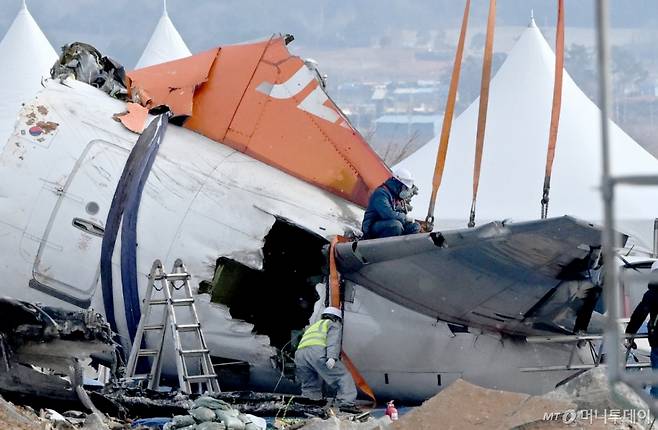 [무안=뉴시스] 김혜인 기자 = 15일 오전 제주항공 여객기 참사가 발생한 무안공항에서 사고 여객기 잔해 수습에 앞서 꼬리 동체를 중장비에 연결하는 작업을 하고 있다. 2025.01.15. hyein0342@newsis.com /사진=