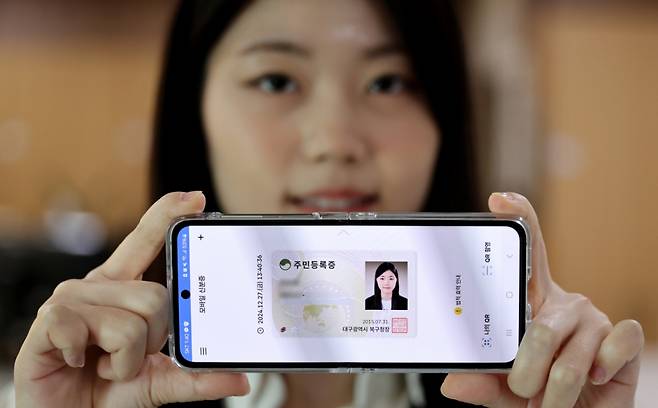 지난해 12월 27일 대구 군위군 부계면사무소에서 한 시민이 발급받은 모바일 주민등록증을 들어 보이고 있다.  행정안전부는 이날부터 세종시, 경기 고양시, 경남 거창군, 대구 군위군 등 지자체 9곳 대상으로 모바일 주민등록증을 시범 발급한다. /사진=뉴시스