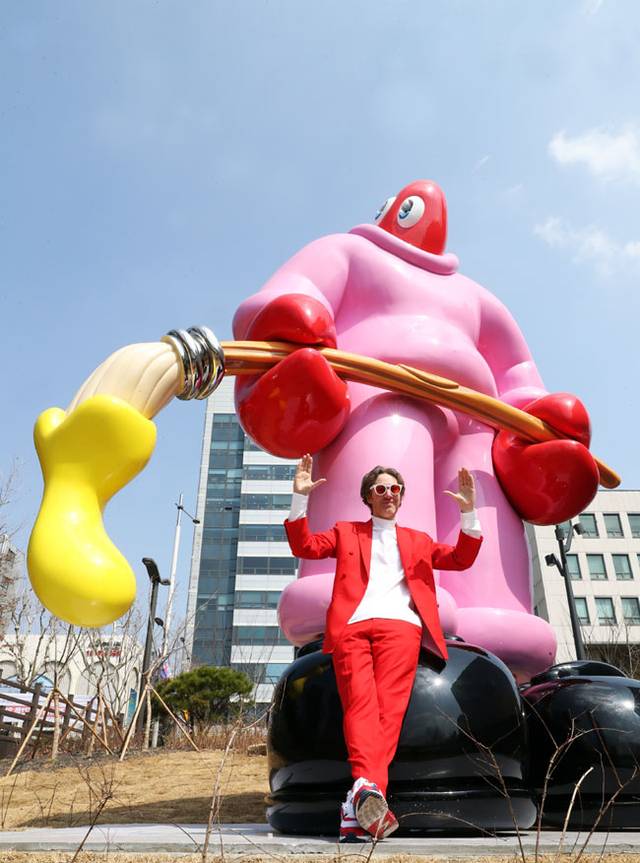 영국의 팝아트 작가 필립 콜버트가 최근 서울 송파구 석촌호수에 설치된 자신의 대형 조각 작품 ‘예술가(The Painter)’ 앞에서 포즈를 취하고 있다. 입이 없는 랍스터 형상의 ‘예술가’는 콜버트 자신이 투영됐다.  더 갤러리 호수 제공
