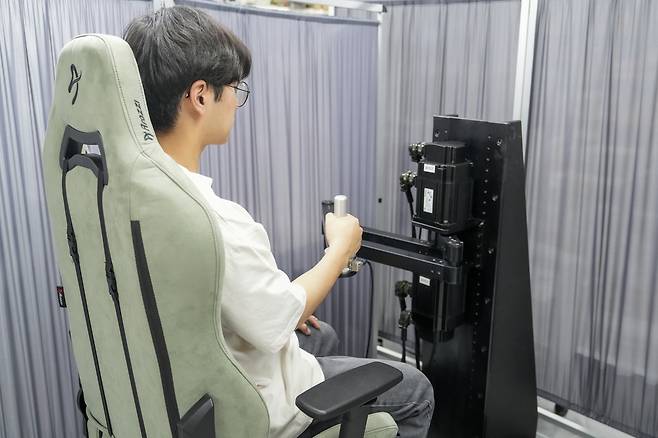 로봇을 이용한 상지 경직 진단 방식. 로봇 팔을 움직이면 사람 팔이 이에 반응하게 되는데, 이 반응을 신호로 측정해 경직도를 진단한다.[UNIST 제공]