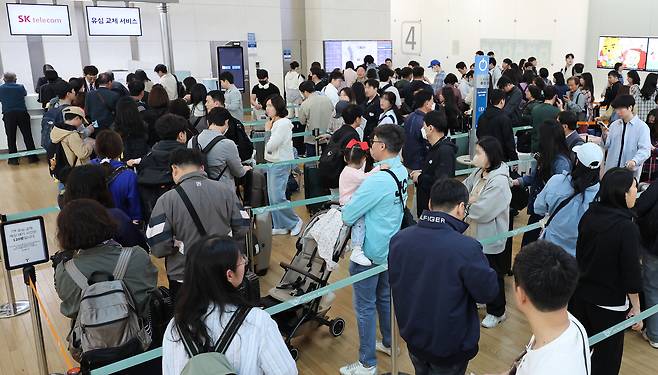 5월 1일부터 엿새간 이어지는 황금연휴를 앞둔 30일 인천국제공항 제1여객터미널 SK텔레콤 로밍센터에서 출국자들이 유심 교체를 위해 대기하고 있다. [연합]