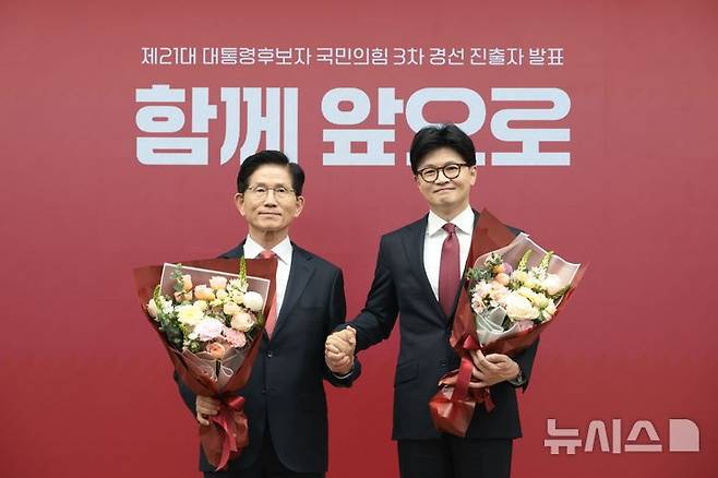 [서울=뉴시스] 국회사진기자단= 국민의힘 2차 경선 결선에 진출한 김문수, 한동훈(오른쪽) 후보가 29일 오후 서울 여의도 중앙당사에서 열린 제21대 대통령후보자 선출을 위한 3차 경선 진출자 발표에서 꽃다발을 들고 기념촬영을 하고 있다.2025.04.25. photo@newsis.com