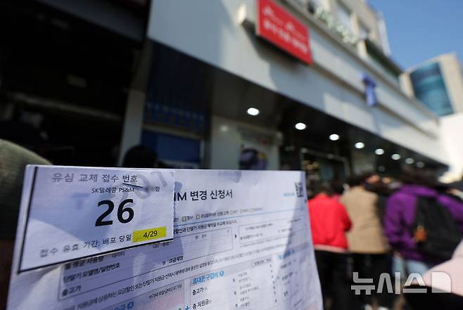 [서울=뉴시스] 홍효식 기자 = SK텔레콤이 유심 고객정보 해킹 사고와 관련 유심 무상 교체를 진행하는 가운데 29일 오전 서울 시내 한 T월드 매장 앞에서 한 고객이 유심 교체 접수 번호를 들고 대기하고 있다. 2025.04.29. yesphoto@newsis.com
