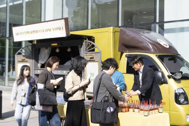 28일 상암동 CJ ENM 센터에서 윤상현(오른쪽) CJ ENM 대표가 CJ 문화사업 출범일(1995년 4월 28일)을 기념해 출근하는 임직원들에게 커피와 간식을 나눠주고 있다. 사진 제공=CJ ENM