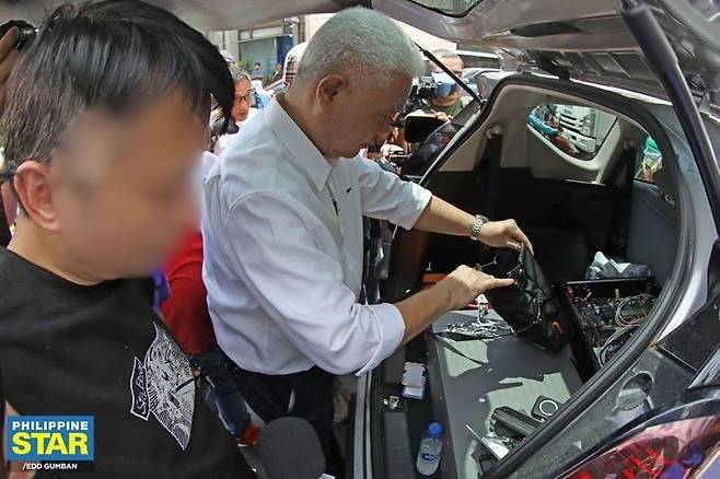 필리핀 총선 앞두고 선관위 주변 도청혐의 중국인 체포 29일(현지시간) 필리핀 수도 마닐라 선관위 사무실 근처에서 수사 당국이 중국인(왼쪽)을 체포하고 차량 내 휴대전화 도청 장비 등을 살펴보고 있다. 2025.04.30
[필리핀스타 홈페이지 캡처. 재판매 및 DB 금지]