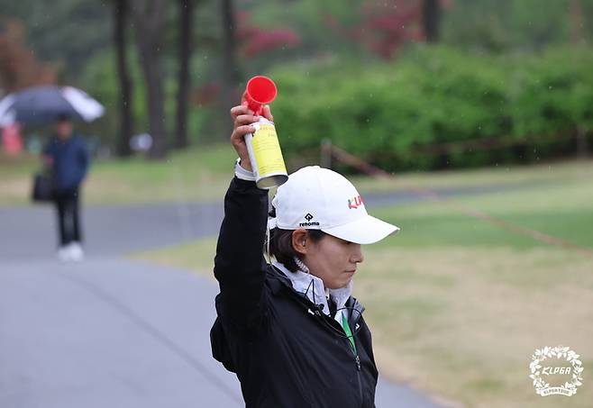 KLPGA 경기위원이 1일 레이크우드CC에서 열린 KLPGA 챔피언십 1라운드 도중 낙뢰 예보가 발령되자 경기 중단을 알리는 혼을 울리고 있다. 사진 | KLPGA