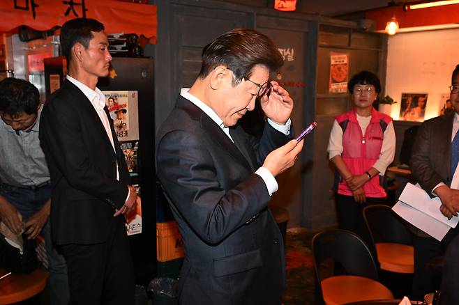 이재명 더불어민주당 대선 후보가 1일 서울 종로구의 한 음식점에서 열린 노동자 간담회 종료 후 당 관계자에게 전달받은 휴대전화를 확인하고 있다. 대법원 전원합의체는 이날 이 후보에게 무죄를 선고한 원심 판결을 파기하고 사건을 서울고법으로 돌려보냈다. /남강호 기자