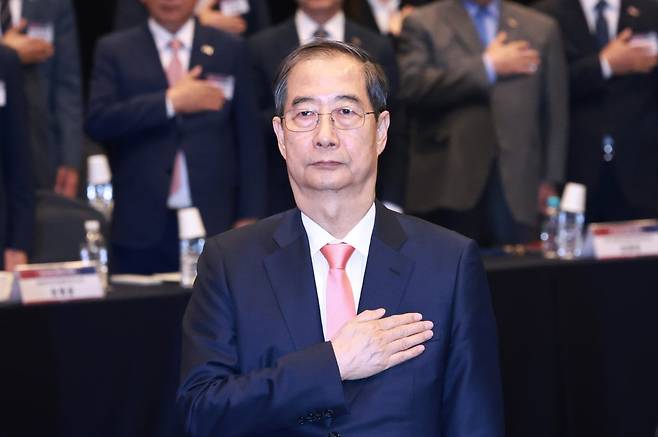 한덕수 대통령 권한대행 국무총리가 30일 서울 영등포구 중소기업중앙회에서 열린 중소기업 규제혁신 현장 소통 간담회에서 국기에 경례를 하고 있다. 2025.04.30. 대통령실통신사진기자단