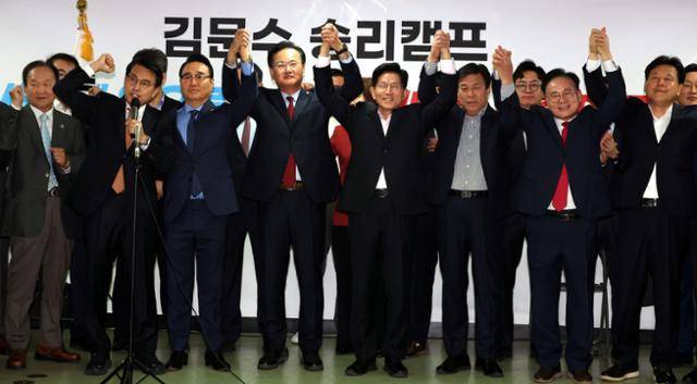 김문수(오른쪽 네번째) 제21대 대통령선거 국민의힘 경선 후보가 30일 오전 서울 여의도 선거캠프에서 지지 선언을 위해 방문한 홍준표 후보 캠프 관계자들과 손을 잡고 기념촬영을 하고 있다. 뉴시스