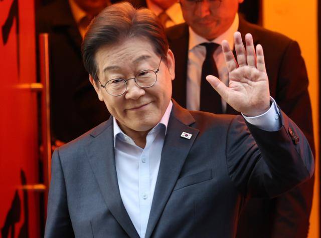 이재명 더불어민주당 대선 후보가 1일 서울 종로구의 한 포장마차 식당에서 배달 라이더, 택배 기사 등 비전형 노동자들과 간담회를 마친 뒤 손인사를 하고 있다. 뉴스1