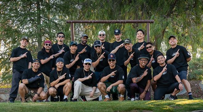 Members of Kinjaz pose with their signature hand sign during a group photo at their 15-year anniversary retreat.  (Courtesy of Kinjaz)
