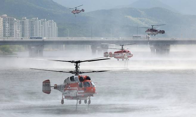 지난달 29일 진화된 대구 북구 함지산 산불이 재발화한 가운데 1일 오전 산림청, 소방 소속 헬기들이 진화작업을 위해 인근 금호강에서 물을 채우고 있다. [사진 = 연합뉴스]