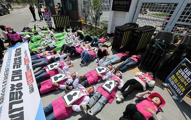 28일 전국학교비정규직연대회의 소속회원들이 정부서울청사 앞에서 정부에 학교급식노동자 산업재해 예방 대책을 요구하는 퍼포먼스를 하고 있다. [연합]