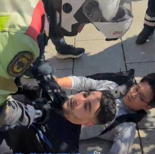 현지 경찰에 멱살이 잡힌 채 끌려가고 있는 소매치기  [X 갈무리]