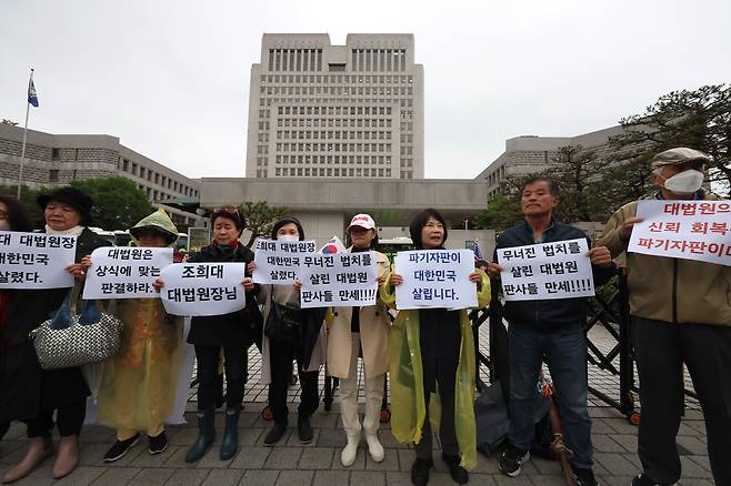 1일 서울 서초구 대법원 앞에서 보수단체 회원들이 더불어민주당 이재명 대선 후보의 공직선거법 위반 혐의 사건이 유죄 취지로 파기환송 되자 이를 반기는 피켓을 들어 보이고 있다. <연합뉴스>