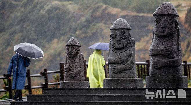 [서귀포=뉴시스] 우장호 기자 = 제주 서귀포시 대정읍 송악산 둘레길에서 우산을 쓴 관광객들이 발걸음을 재촉하고 있다. (사진=뉴시스DB) woo1223@newsis.com