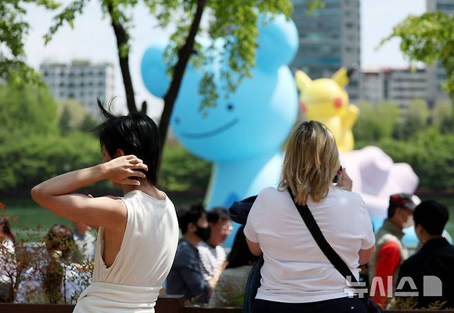 [서울=뉴시스] 김진아 기자 = 서울 낮기온이 26도로 초여름 더위를 보인 지난달 30일 서울 송파구 석촌호수에서 외국인 관광객들이 가벼워진 옷차림으로 시간을 보내고 있다. 2025.04.30. bluesoda@newsis.com