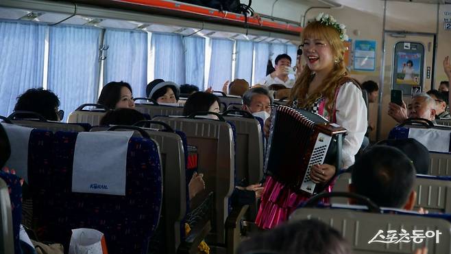 ‘충남 레트로 낭만열차’에서 진행하는 싱어롱 프로그램. 아코디언을 연주하며 경쾌한 멜로디의 요들을 부르는 공연자와 승객들이 한데 어우러져 흥겹다           충남｜김재범 기자 oldfield@donga.com