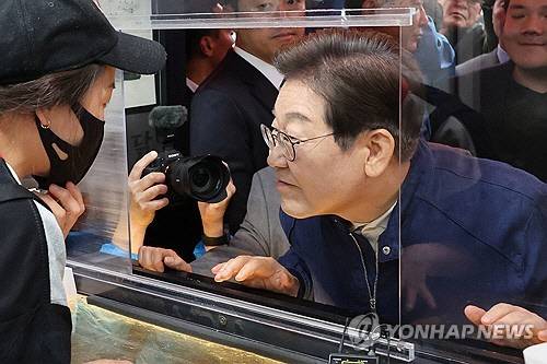 민심을 듣는 '골목골목 경청 투어'를 시작한 이재명 더불어민주당 대선 후보가 1일 경기도 북부 접경지역인 포천의 한 치킨집에서 상인과 대화하며 귀를 기울이고 있다.    [연합뉴스]