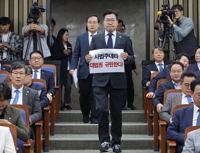 대법원이 더불어민주당 이재명 대선후보의 공직선거법 위반 혐의 2심 무죄판결을 파기 환송한 1일 서울 여의도 국회에서 열린 민주당 긴급의원총회에서 박찬대 원내대표가 대법원 규탄 손팻말을 들고 입장하고 있다. 연합뉴스