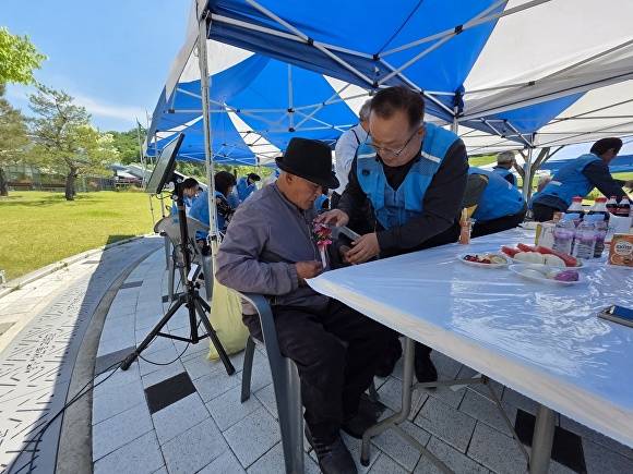 배해석 성주읍장(오른쪽)이 지역 어르신에게 어버이날 기념 꽃을 달아드리고 있다 [사진=성주군]