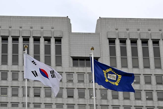 The national flag and the Supreme Court’s flag flutter in the wind outside the Supreme Court in Seocho-gu, Seoul, on Wednesday. (Im Se-jun/The Korea Herald)