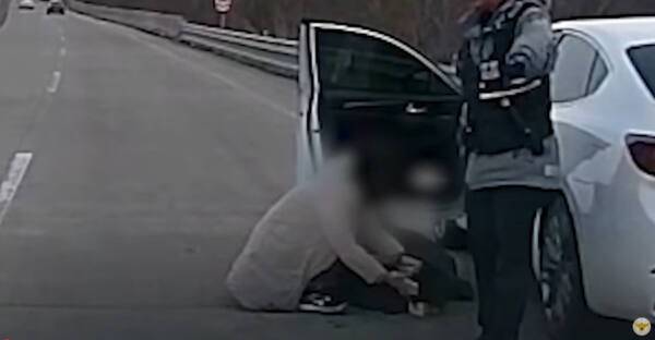 지난 4월13일 고양시의 한 자동차 전용도로에서 한 여성이 심장 고통을 호소하며 쓰러진 남편 A씨를 븥잡고 울고 있다. 현장에 도착한 경찰은 신속히 A씨를 병원으로 이송했다. 경찰청 유튜브 갈무리