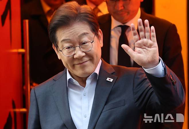 [서울=뉴시스] 조성우 기자 = 이재명 더불어민주당 대선후보가 지난 1일 오후 서울 종로구의 한 포장마차에서 열린 비전형 노동자 간담회를 마치고 나오며 손을 들어 보이고 있다. 대법원 전원합의체는 이날 이 후보에게 무죄를 선고한 원심 판결을 파기하고 사건을 서울고법으로 돌려보냈다. (공동취재) 2025.05.01. photo@newsis.com