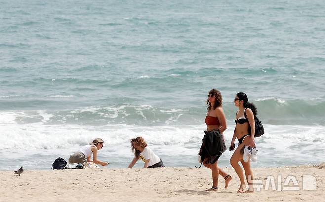 [부산=뉴시스] 하경민 기자 = 전국에 초여름 더위가 찾아온 18일 부산 해운대구 해운대해수욕장을 찾은 외국인들이 더위를 식히고 있다. 2025.04.18. yulnetphoto@newsis.com
